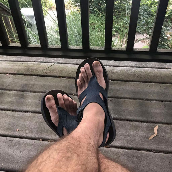 POV of man wearing Albion Sandals on a wooden porch