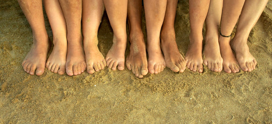 A cluster of bare feet on sand