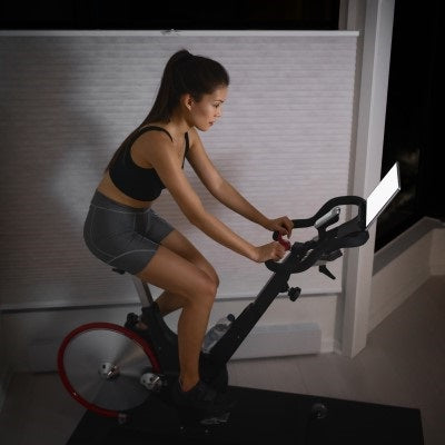 Woman riding a Peloton bike