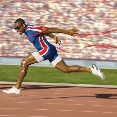 Professional sprint runner crossing the finish line.