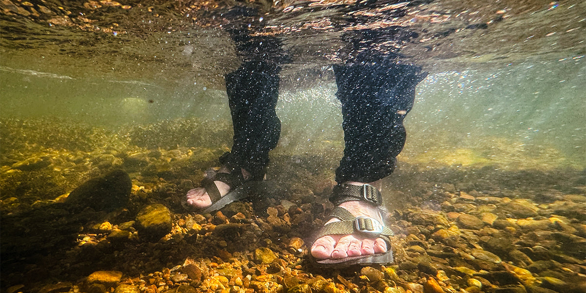 Underwater shot of man wearing Men's Redway Sandals on a rocky riverbed