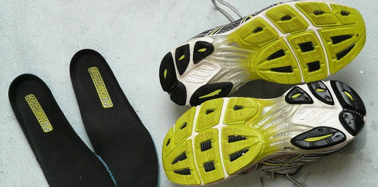 Pair of running shoes with the insoles removed. The running shoes are upside-down so the outsole is visible.