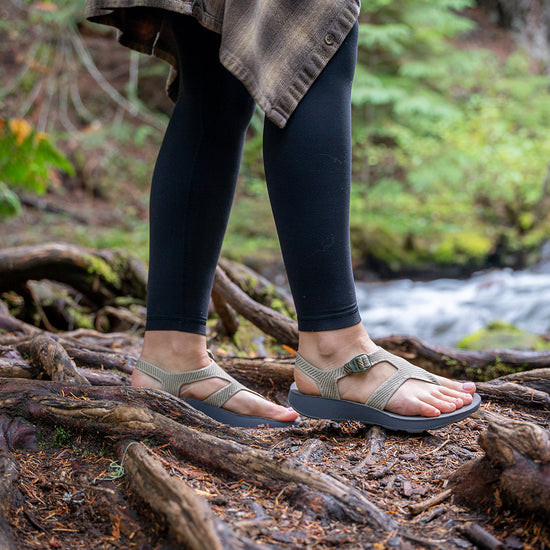Woman wearing supportive Albion Sandals hiking in the woods