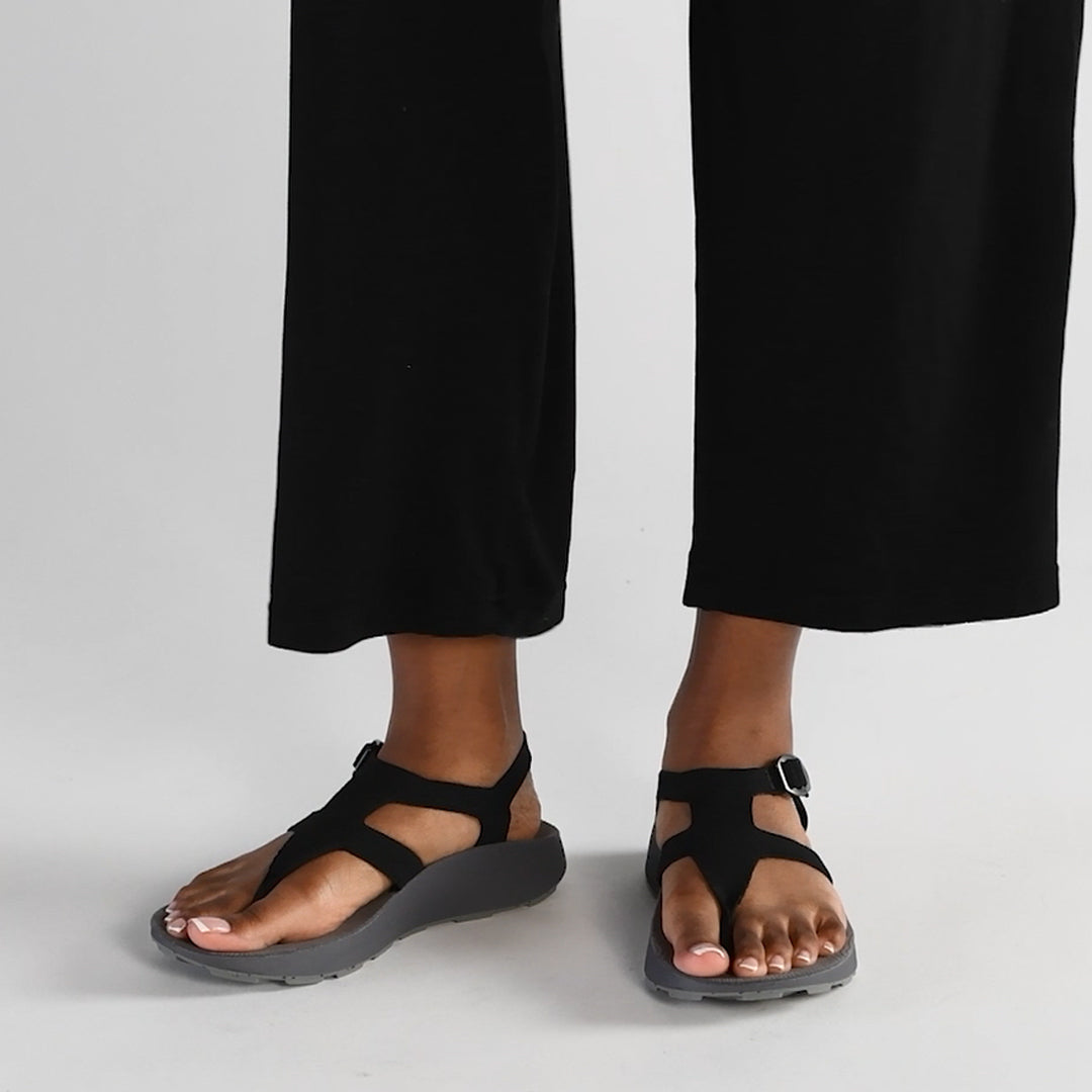 Female model wearing black Albion Sandals in a white studio background