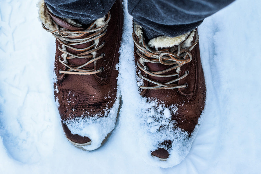 Two leather boots covered in snow