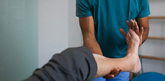 Foot and ankle getting stretched by a podiatrist with the Posterior Tibial Tendon highlighted in red