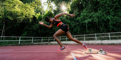 A woman sprinting off the blocks on a track