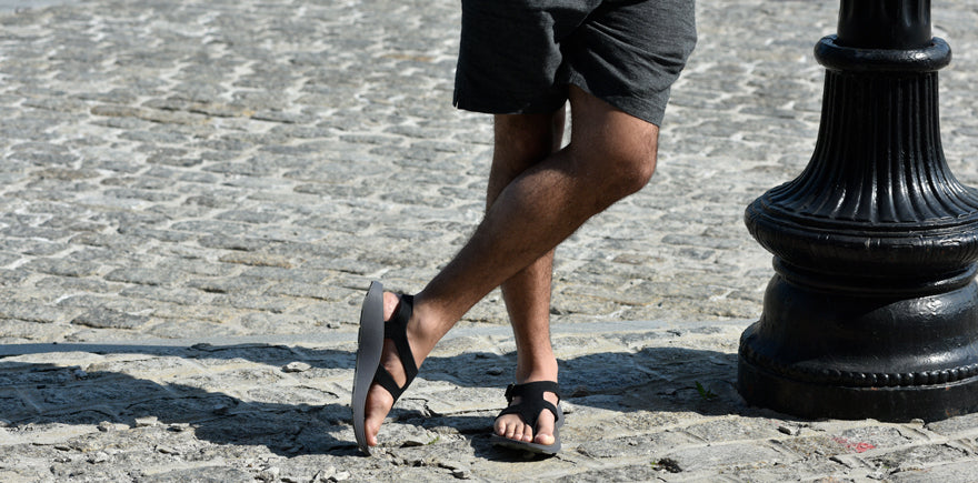 man wearing black sandals standing in the sun
