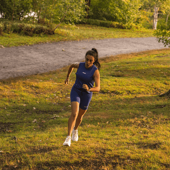 A woman running up a grassy hill
