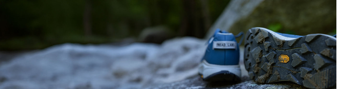 Close-up of a hiking shoe with a Tread Labs logo on a natural background