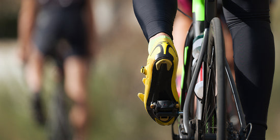 Closeup of cyclist on a road bike wearing cycling shoes with Tread Labs insoles inside