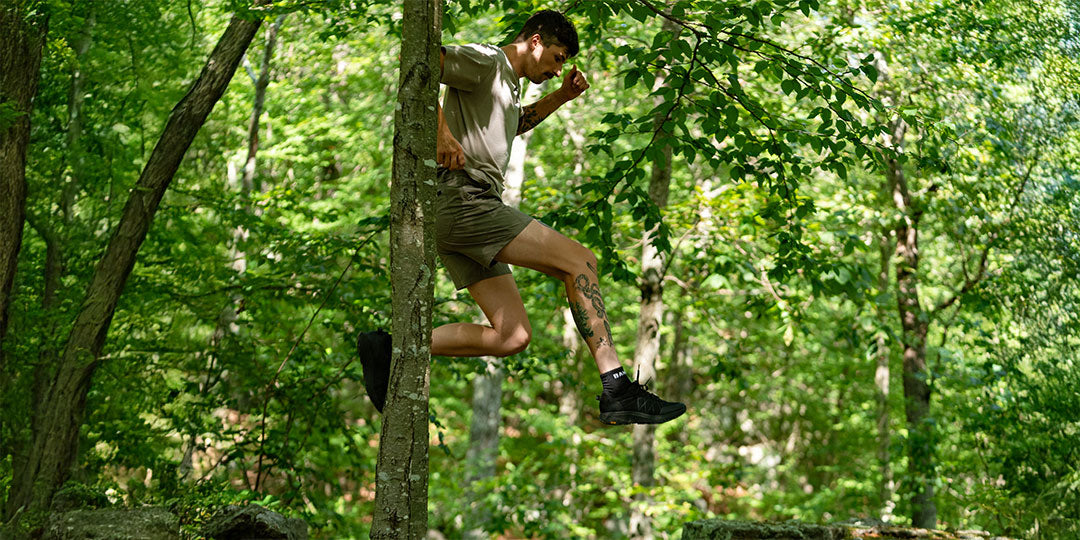 Person jumping on a trail in a forest