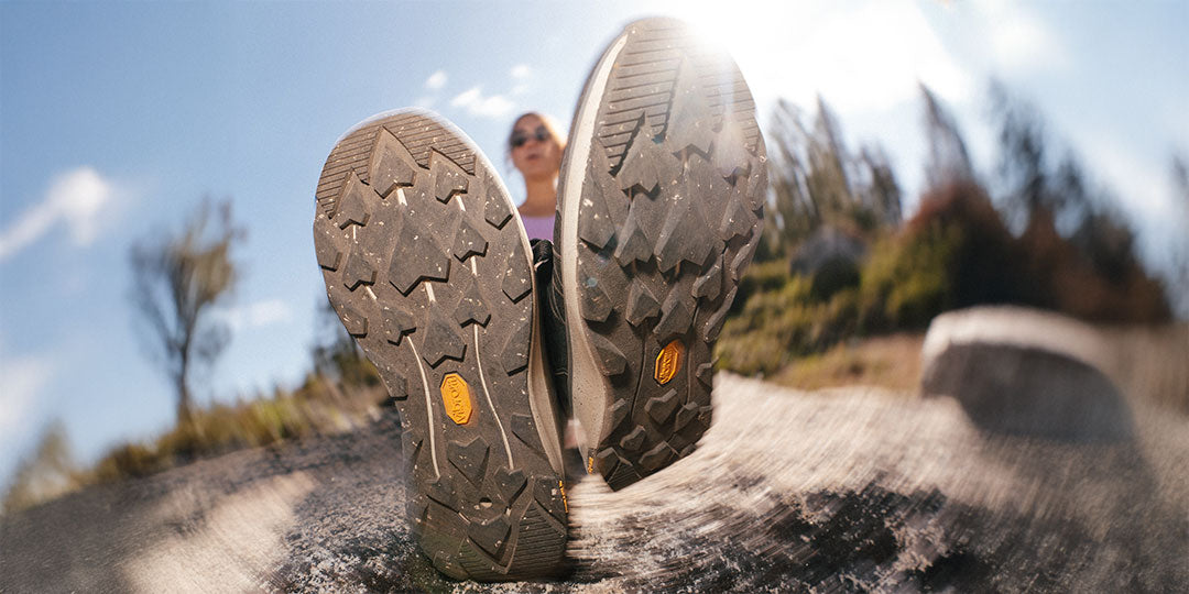 Close-up of hiking shoes on a rock with a blurred natural background