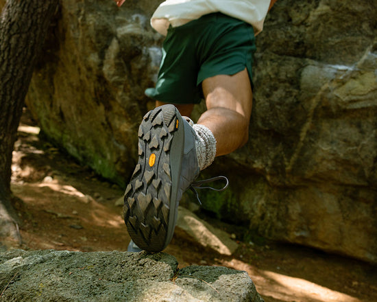 Person wearing hiking shoes on a rocky surface