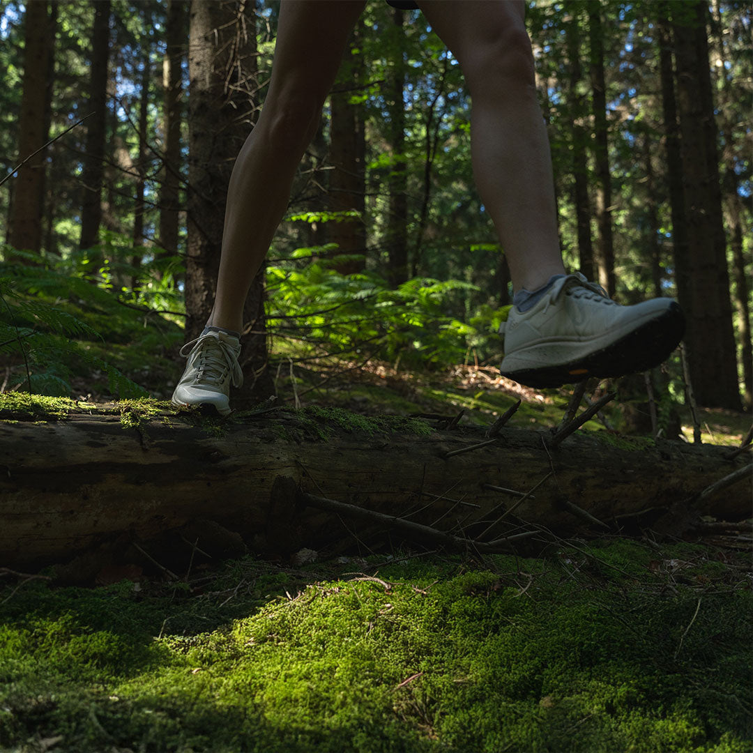 Person walking on a log in a forest
