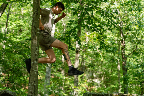 Person jumping through trees in a forest