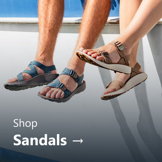 Man and woman wearing Tread Labs sandals sitting on a boat.