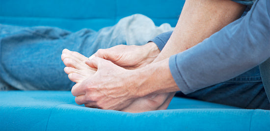 Person massaging their forefoot to find relief from metatarsalgia pain